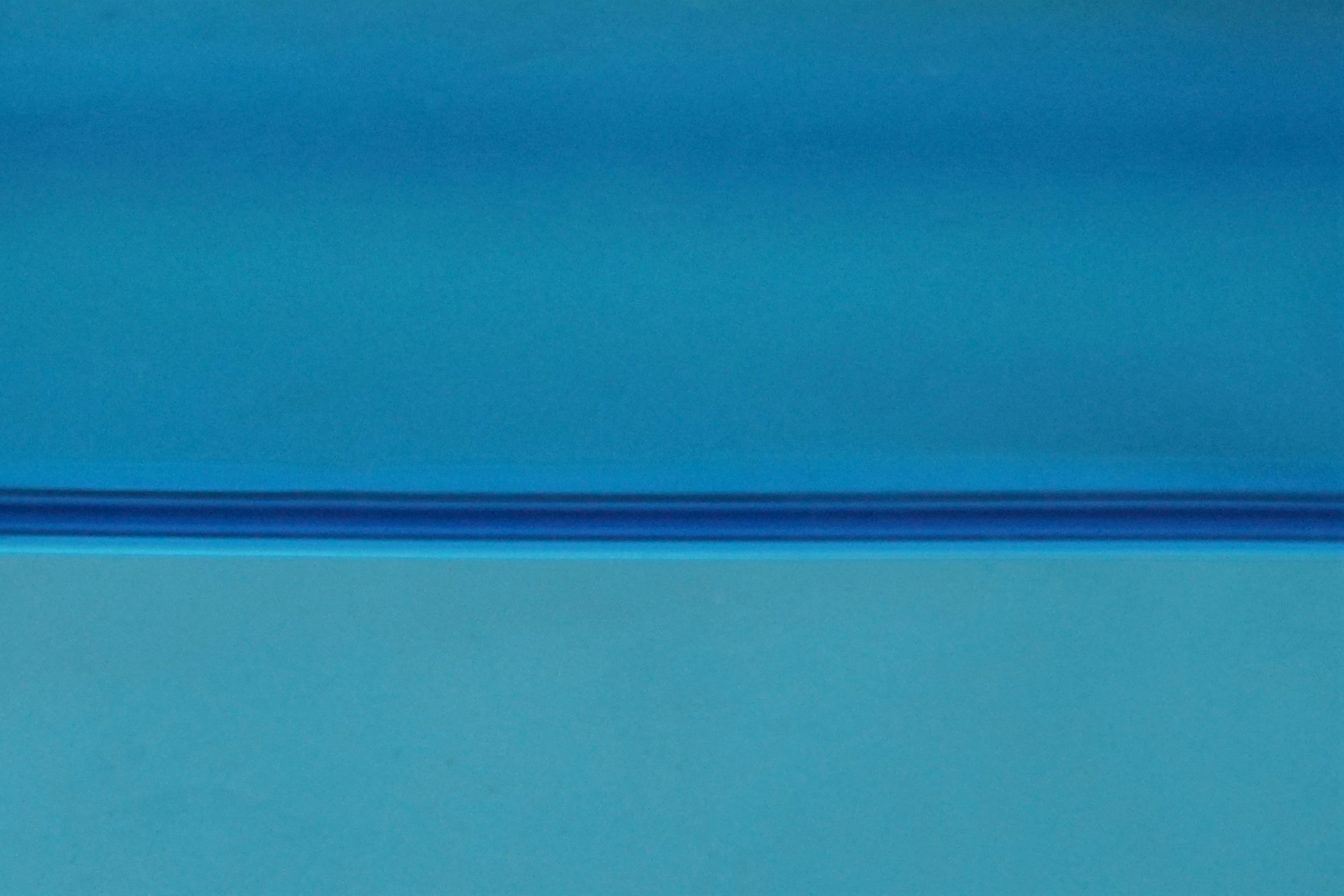 A minimal blue horizon separating two expansive fields of color